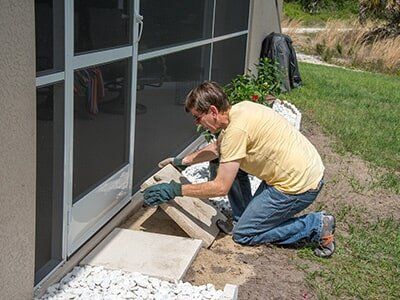 A Person Laying Pavers At their Door — Landscaping Products  in Mudgee, NSW