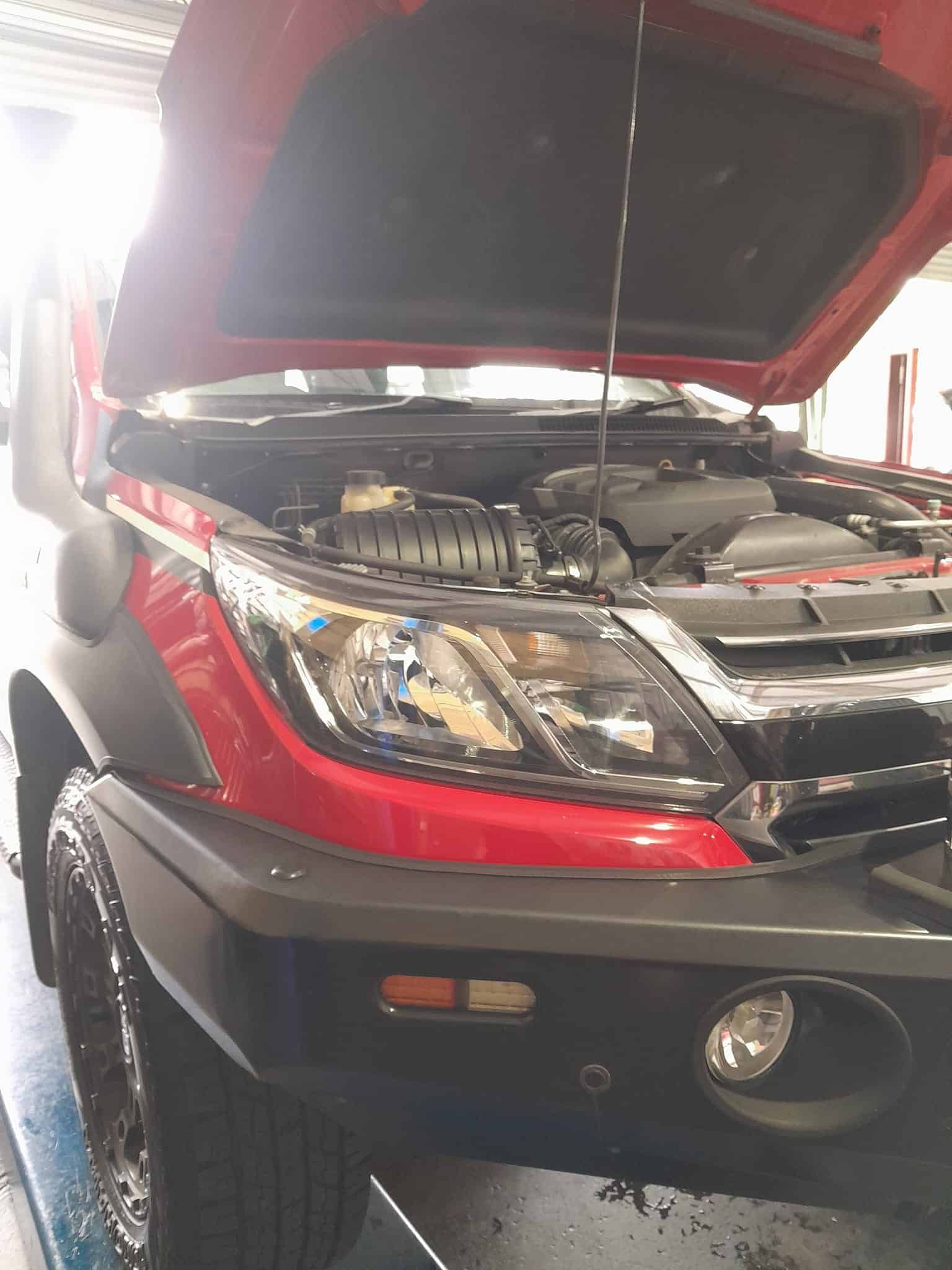 A Red Truck With the Hood Up is Parked in a Garage — CB Automotive In Yatala, QLD