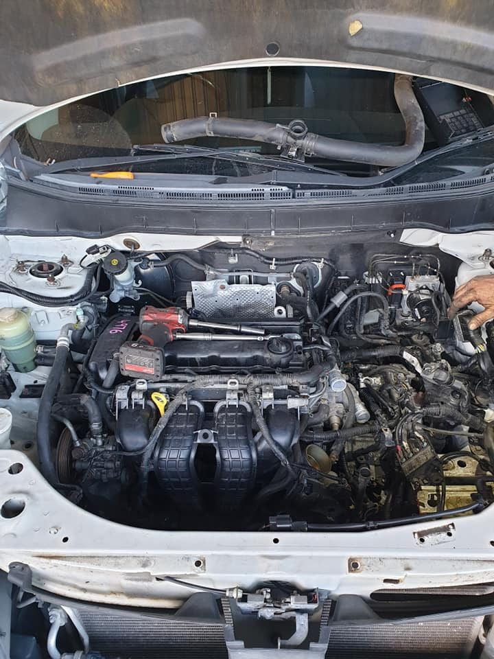 A Man is Working on the Engine of a Car With the Hood Open — CB Automotive In Yatala, QLD
