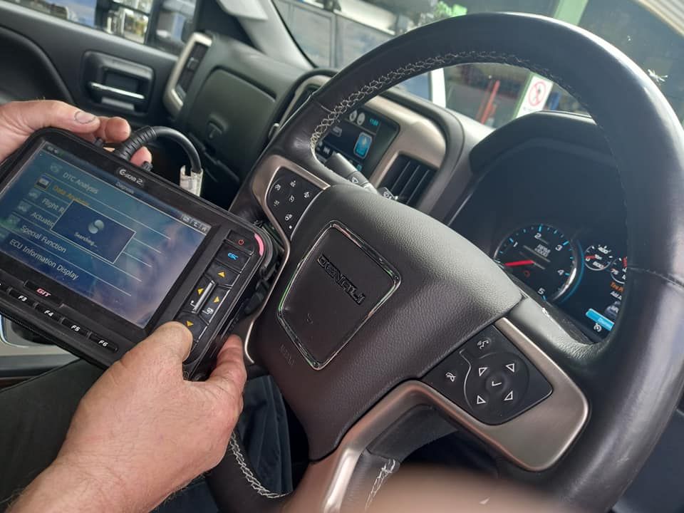 A Person is Holding a Device in Front of a Steering Wheel in a Car — CB Automotive In Yatala, QLD