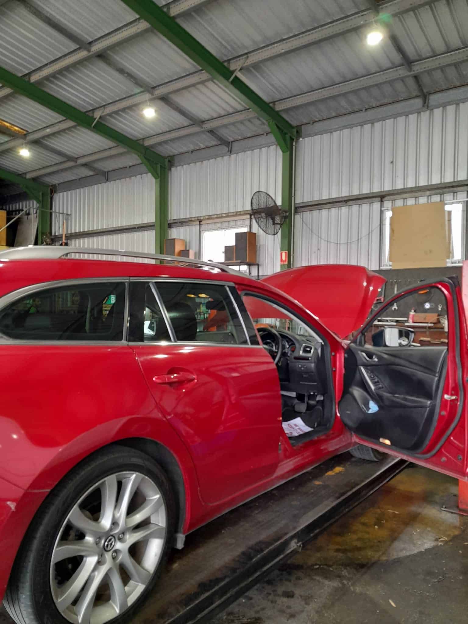 A Red Car is Parked in a Garage With Its Hood Open — CB Automotive In Yatala, QLD