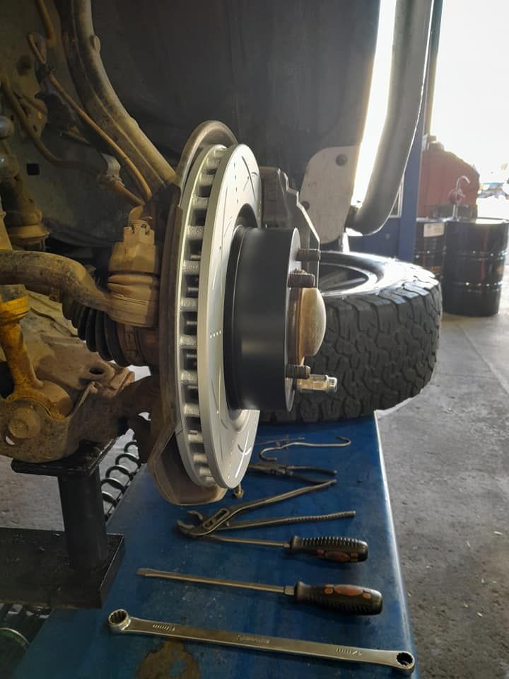 A Brake Disc is Sitting on Top of a Blue Table With Tools — CB Automotive In Yatala, QLD