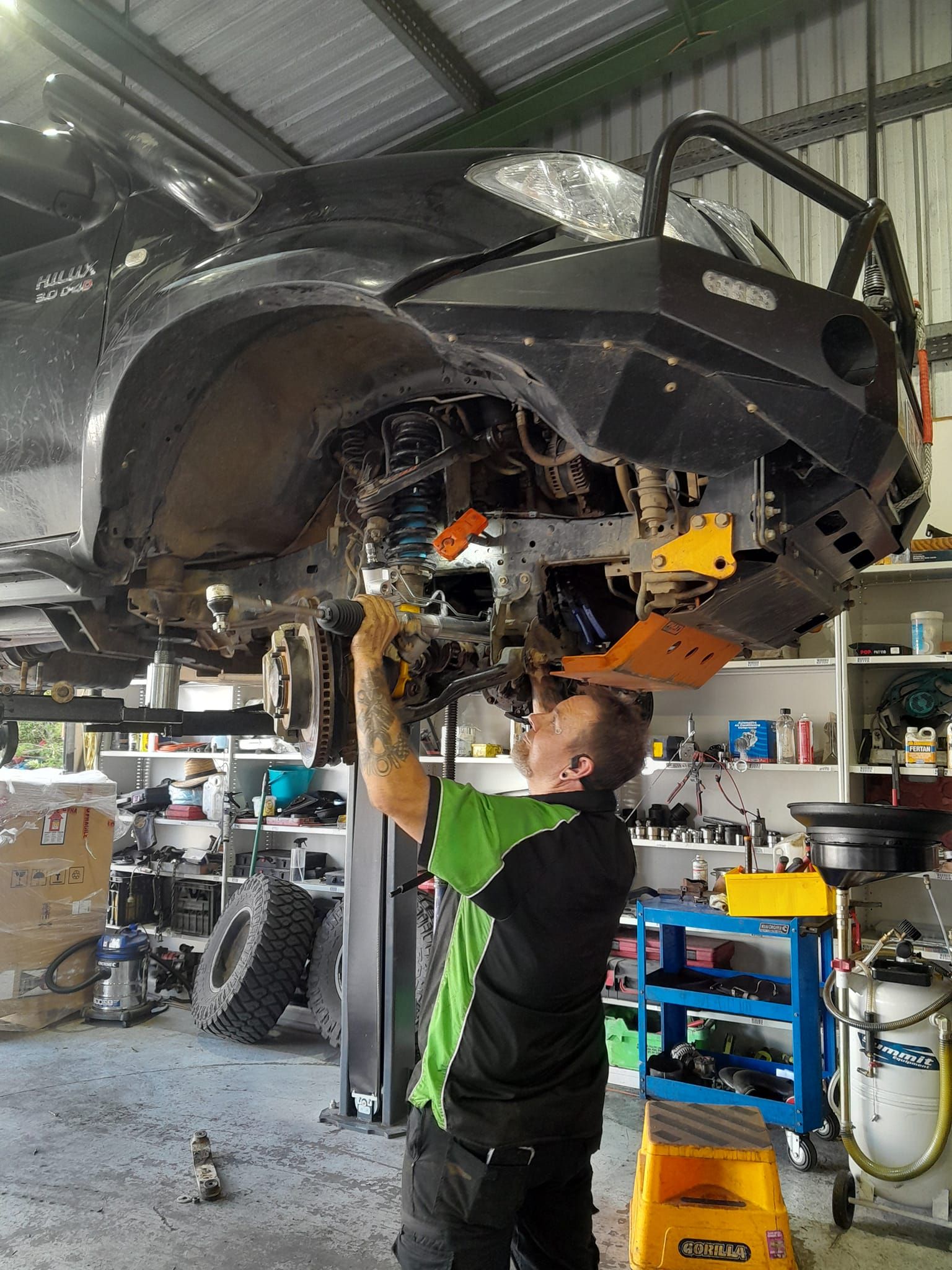 A Man is Working on the Underneath of a Car — CB Automotive In Yatala, QLD