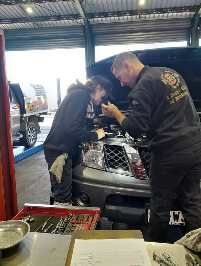 Two Men Are Working on a Truck Engine in a Garage — CB Automotive In Yatala, QLD
