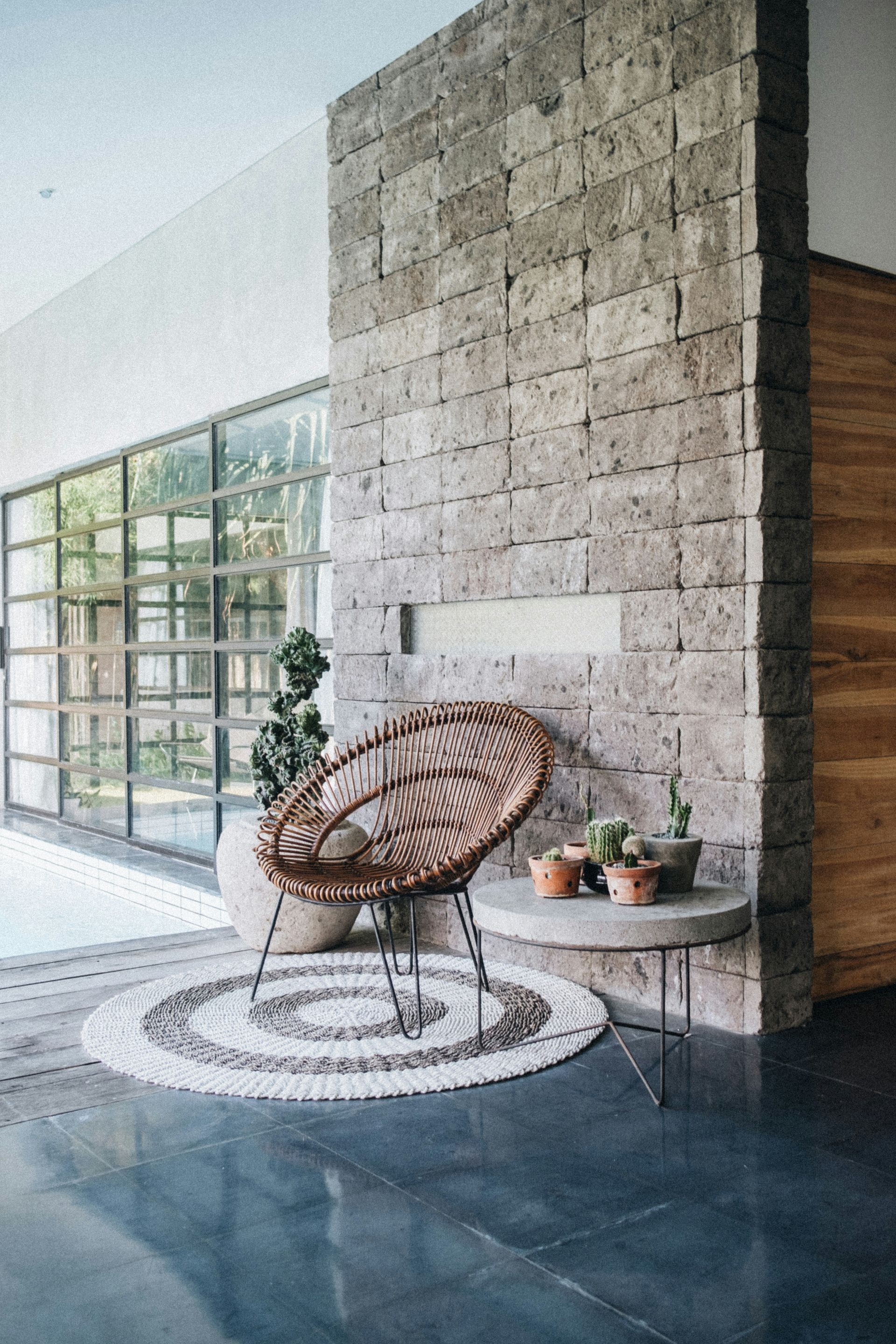 A wicker chair is sitting next to a table in a living room.