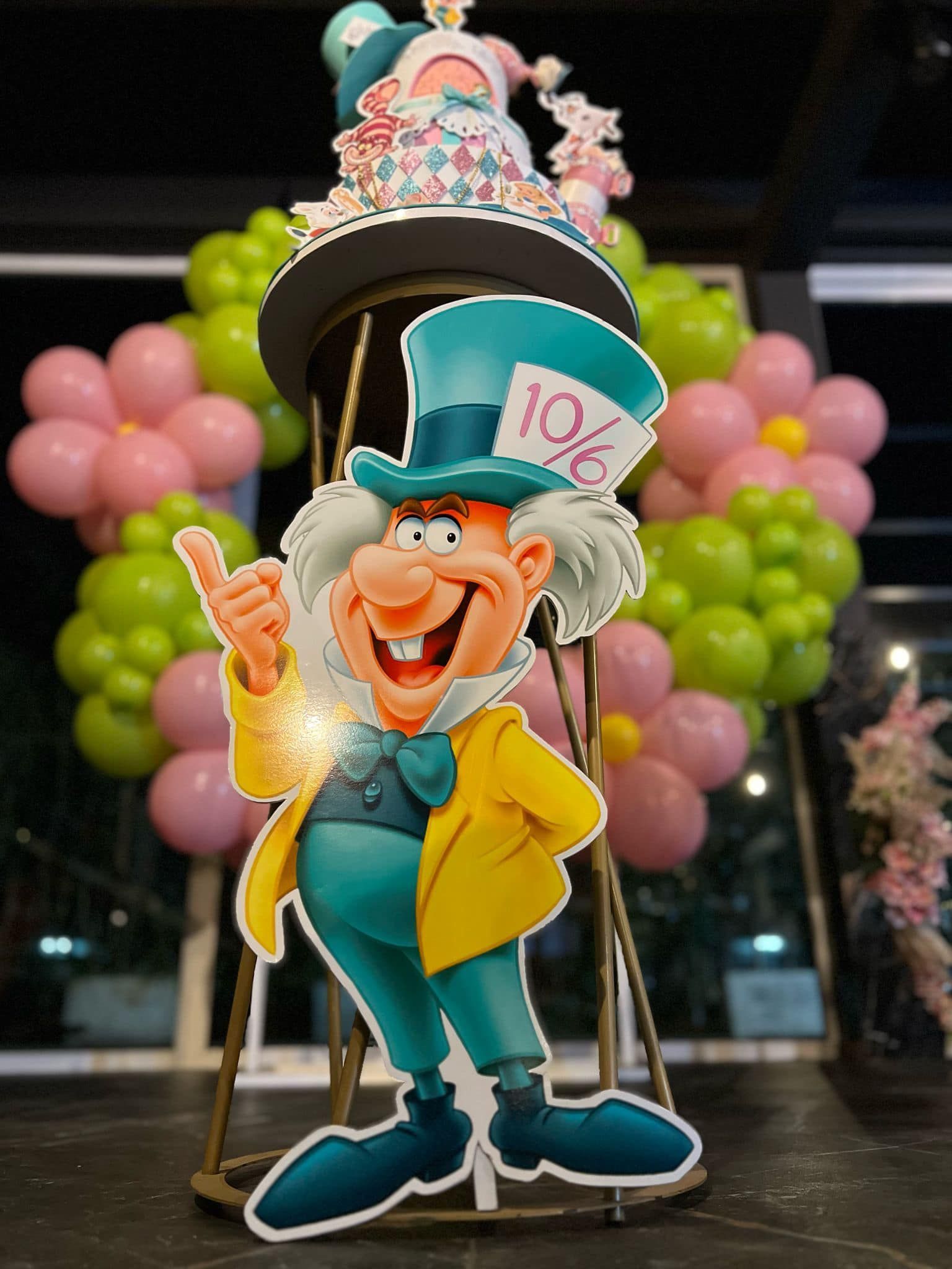 Sagoma di cartone del Cappellaio Matto con palloncini e una torta.