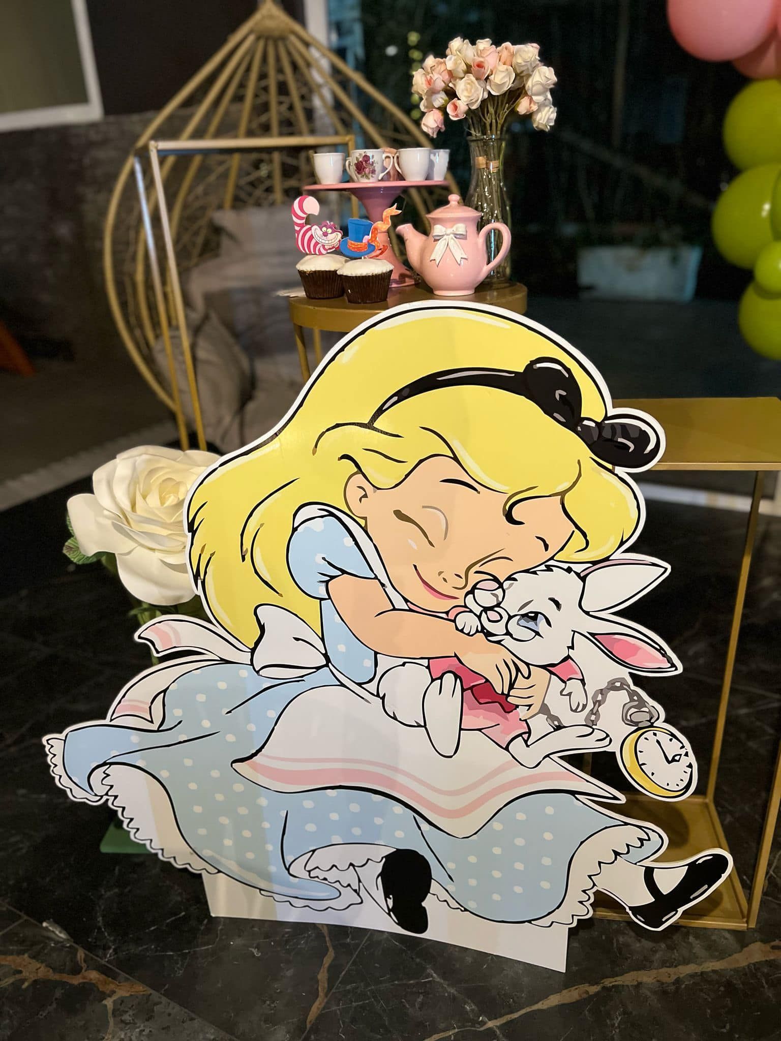 Ritaglio di Alice nel Paese delle Meraviglie che abbraccia il Bianconiglio a una festa a tema, con un tea party allestito sullo sfondo.