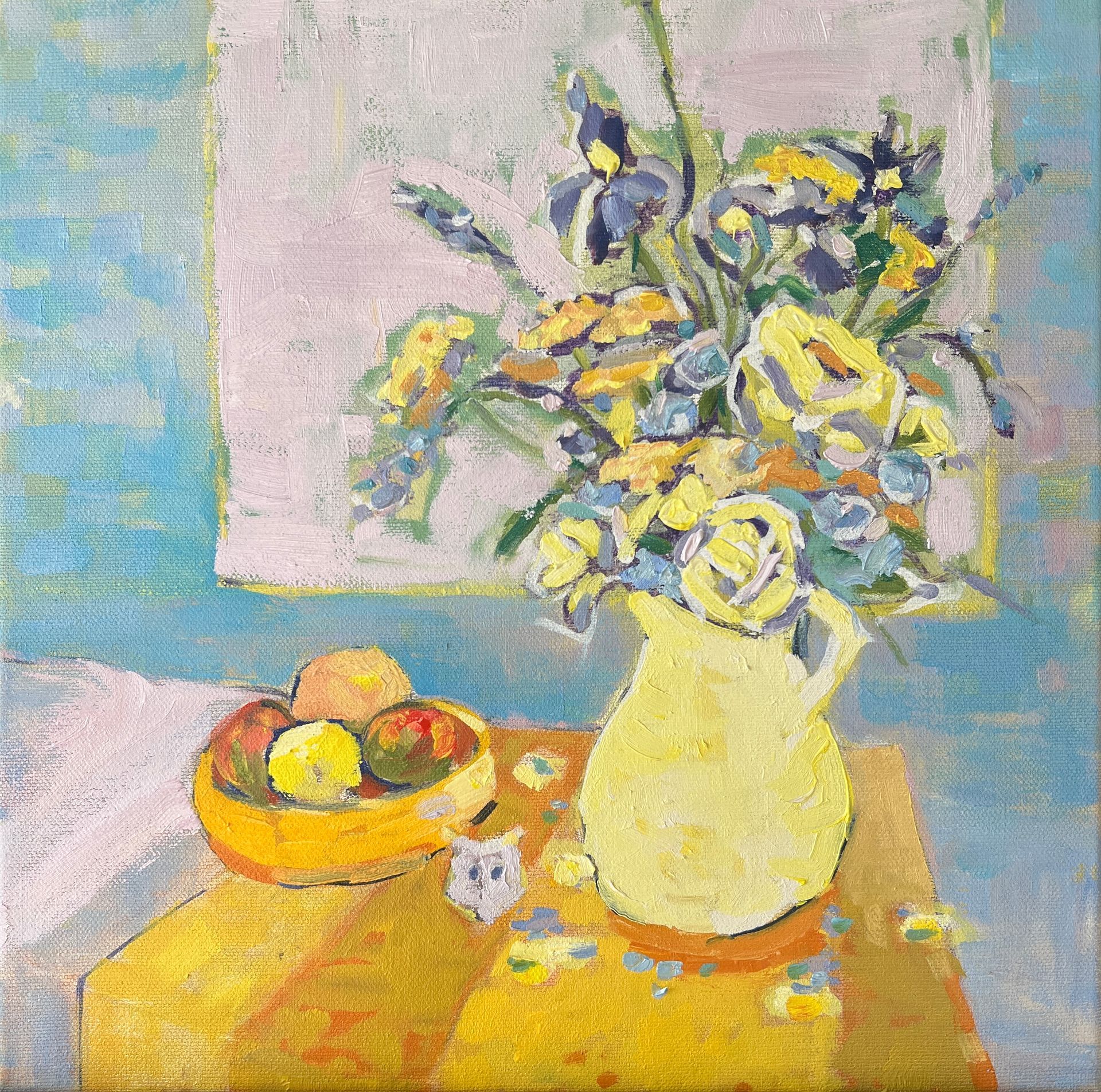 Spring flowers in a jug sitting on a sunny tablecloth