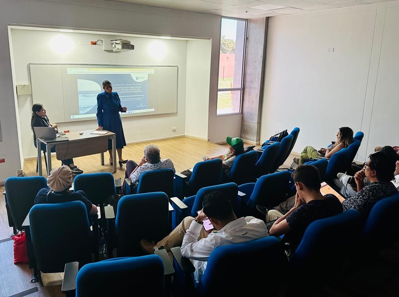 Una mujer está dando una presentación a un grupo de personas en una sala de conferencias.