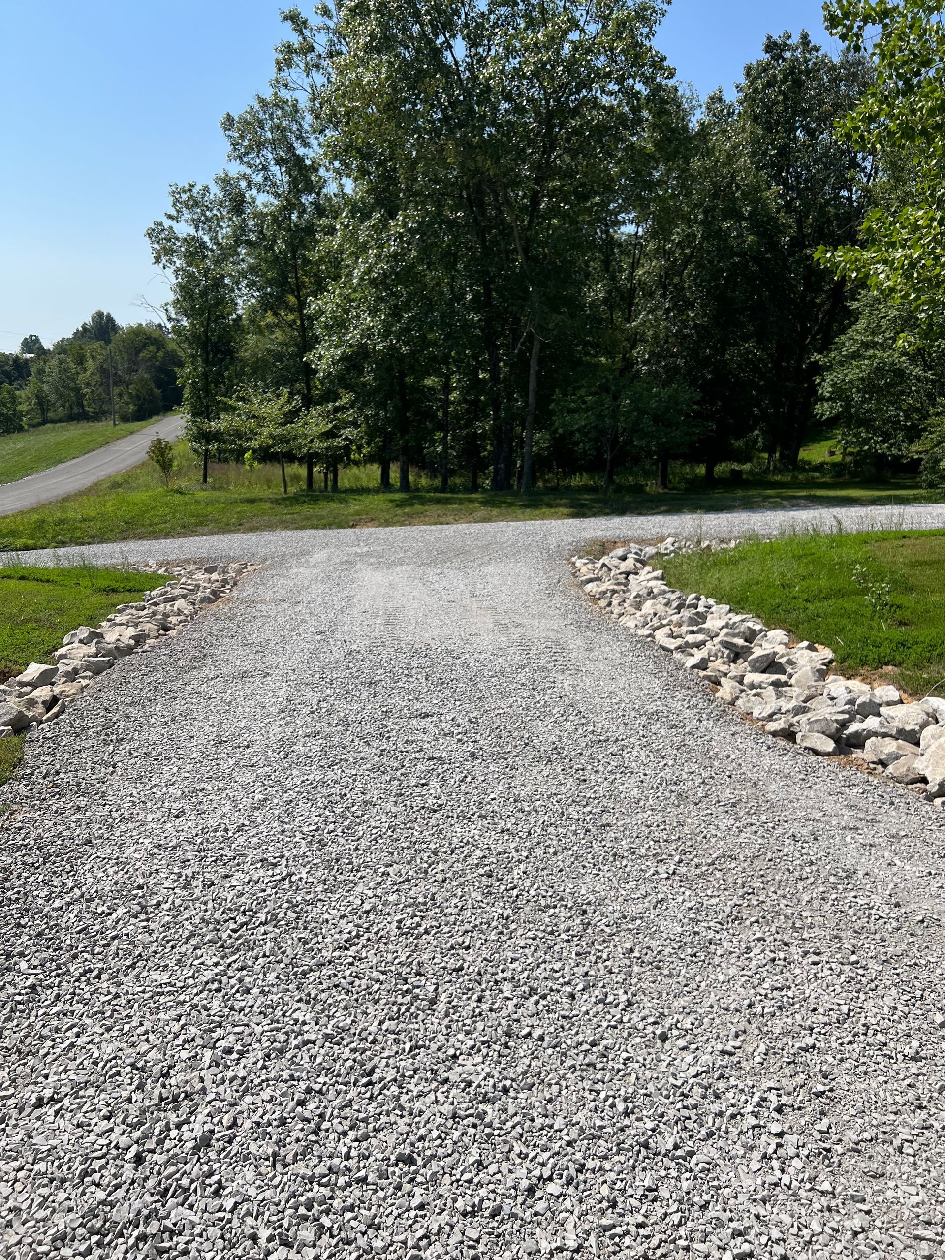 A gravel road with trees on the side of it