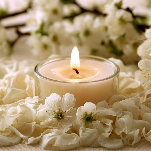 Memorial candle and white blossoms symbolize cremation services in Gilbert, AZ.