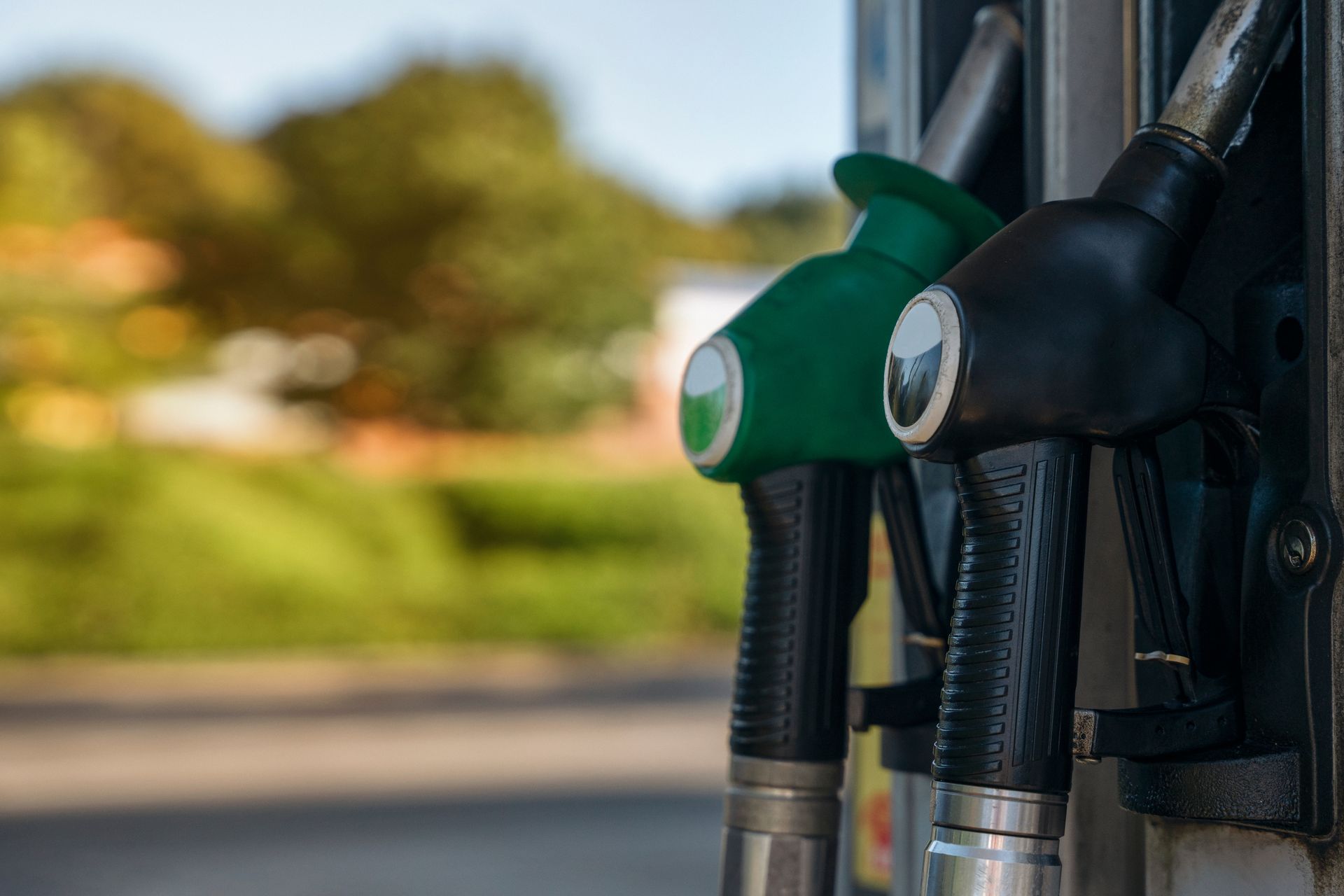 Woman looking at phone next to car on a tow truck. Tow truck operator in background.