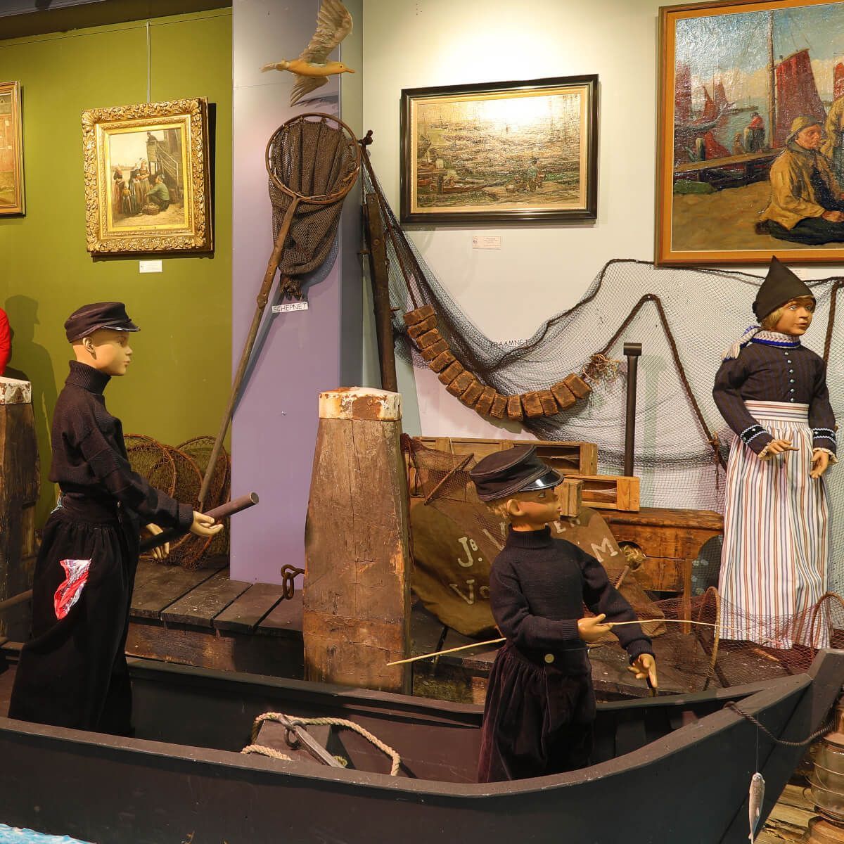 Twee Volendammers staan ​​in een boot in een museum
