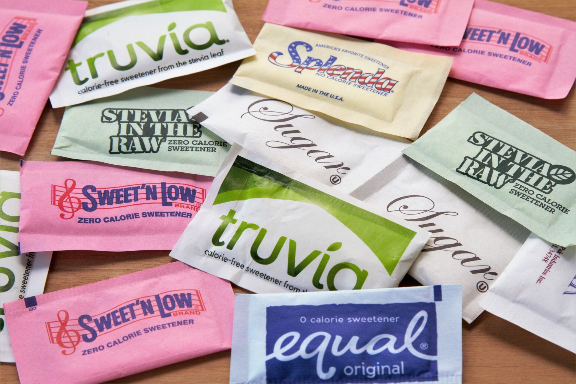 A pile of different types of sweeteners including truvia and equal