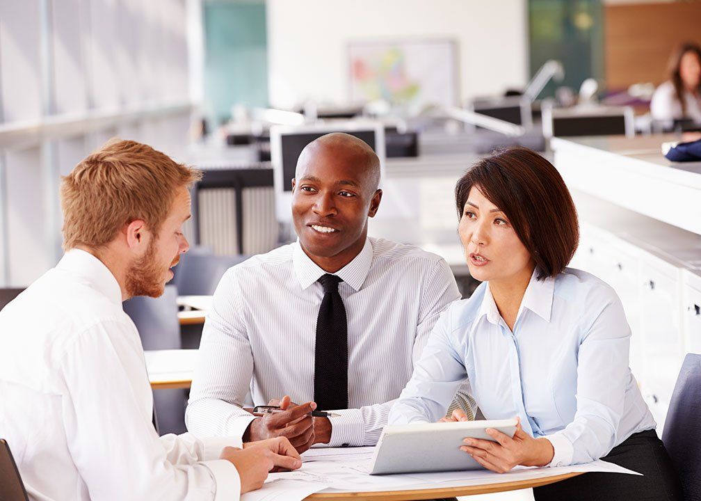 three colleagues talking round a table