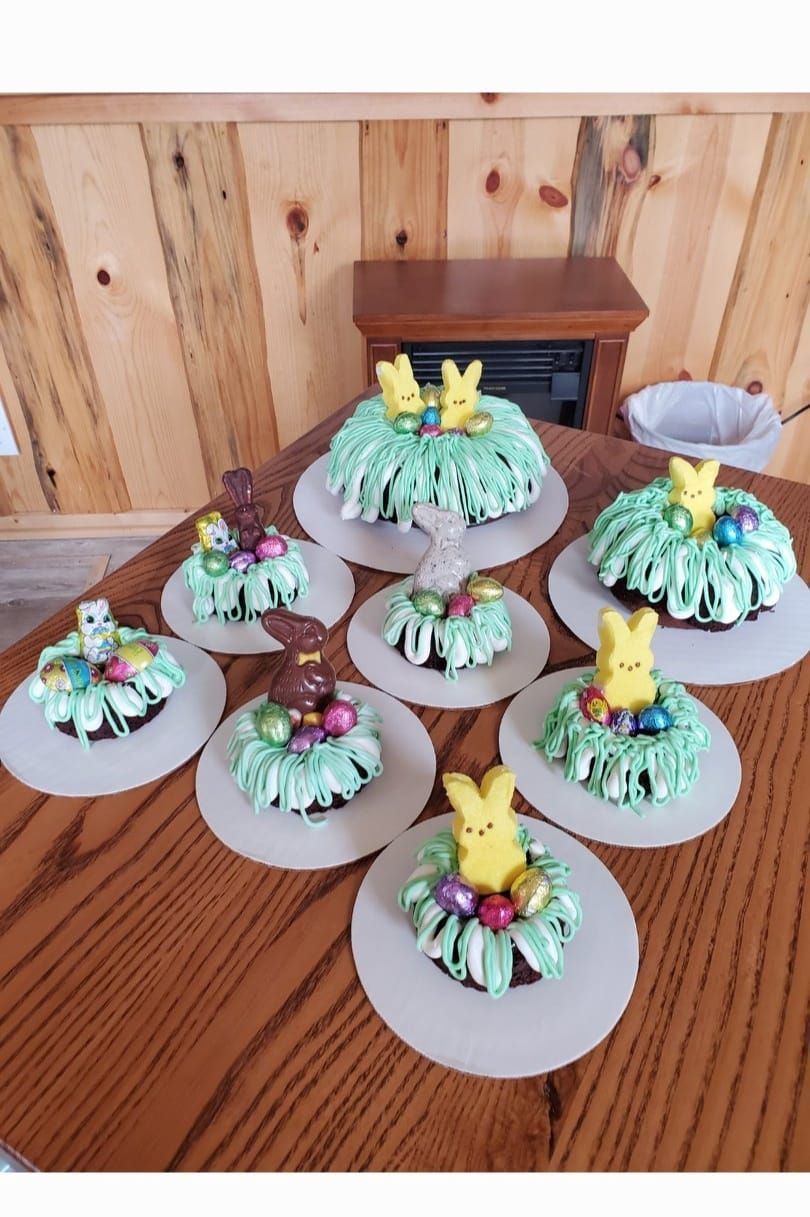 A bunch of cupcakes are sitting on a wooden table.