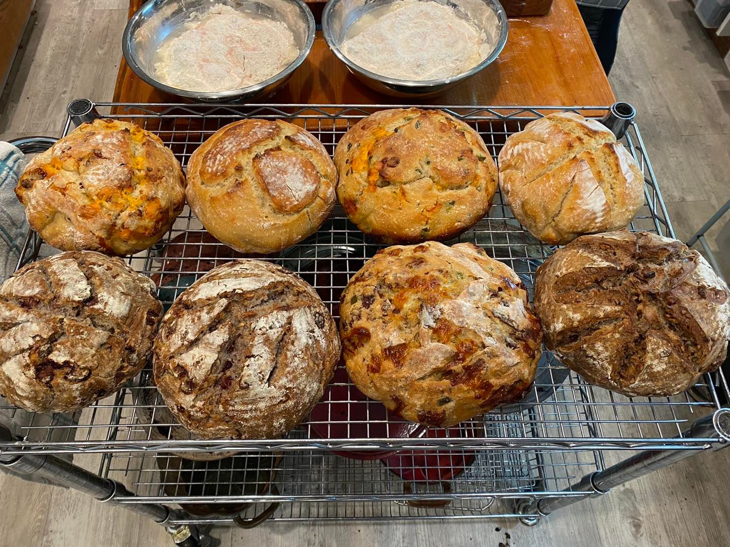 A bunch of different types of bread are sitting on a cooling rack.