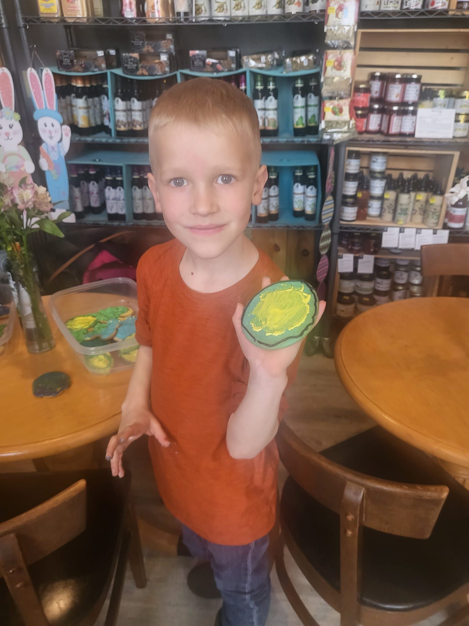 A young boy is holding a cookie in a store.