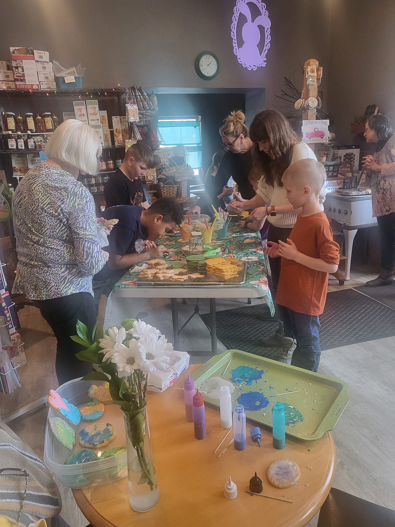 A group of people are standing around a table in a room.