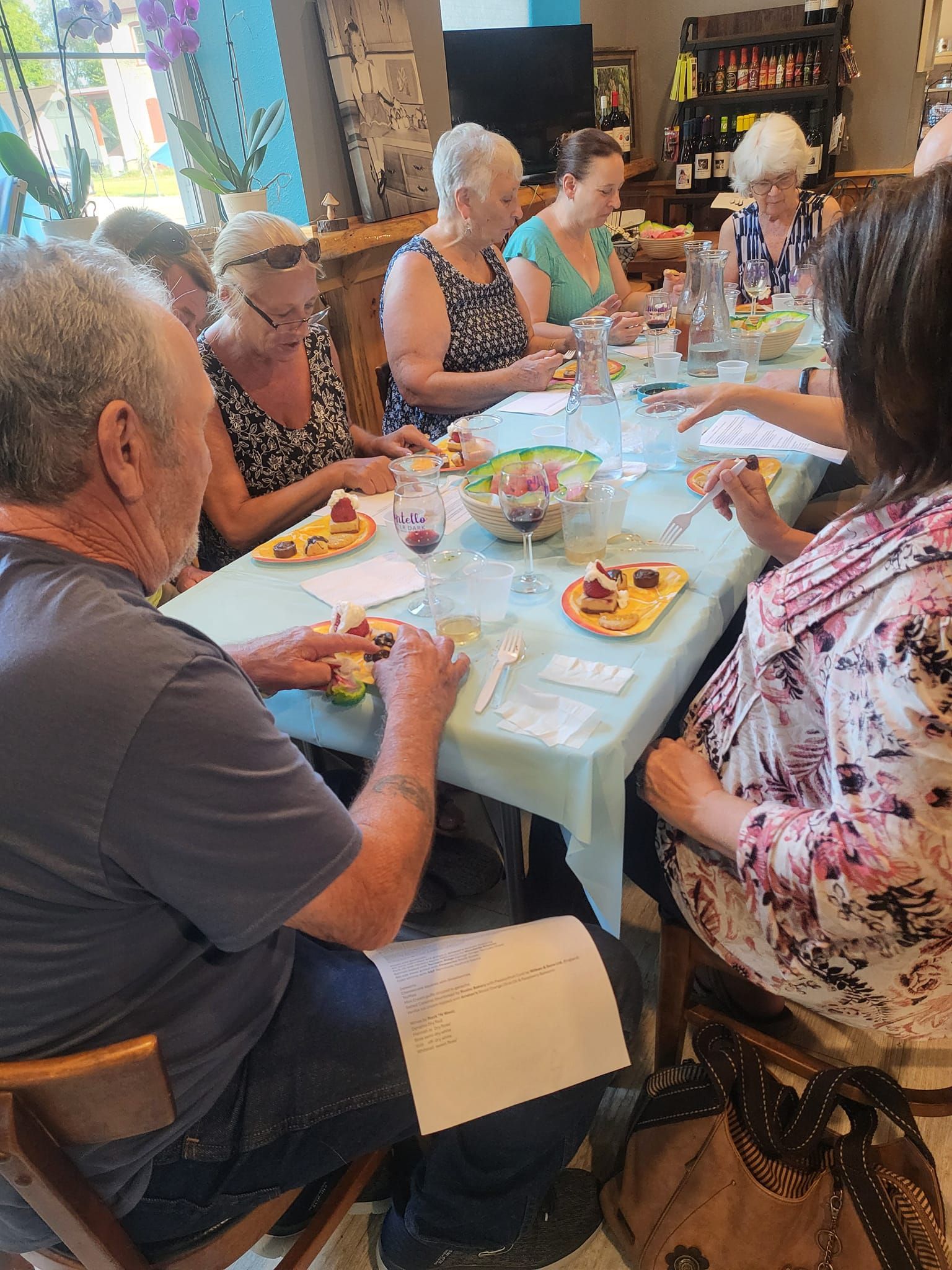 A group of people are sitting around a table eating food.