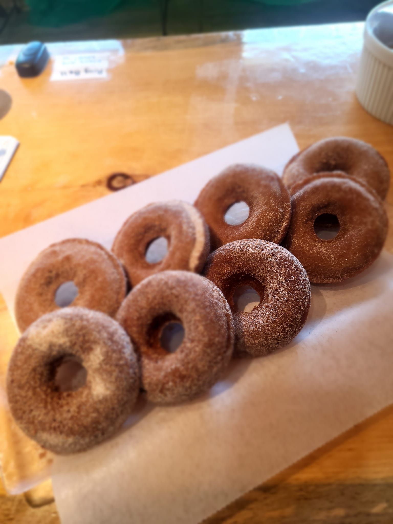 A bunch of donuts are sitting on a wooden table