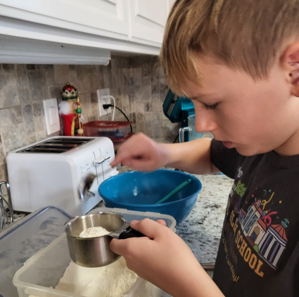 A young boy wearing a black shirt that says preschool