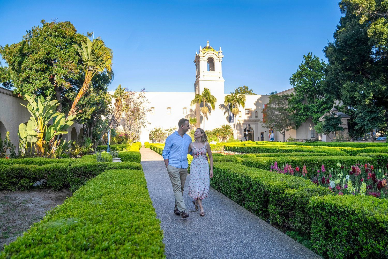 A man and a woman are walking down a path in a park.