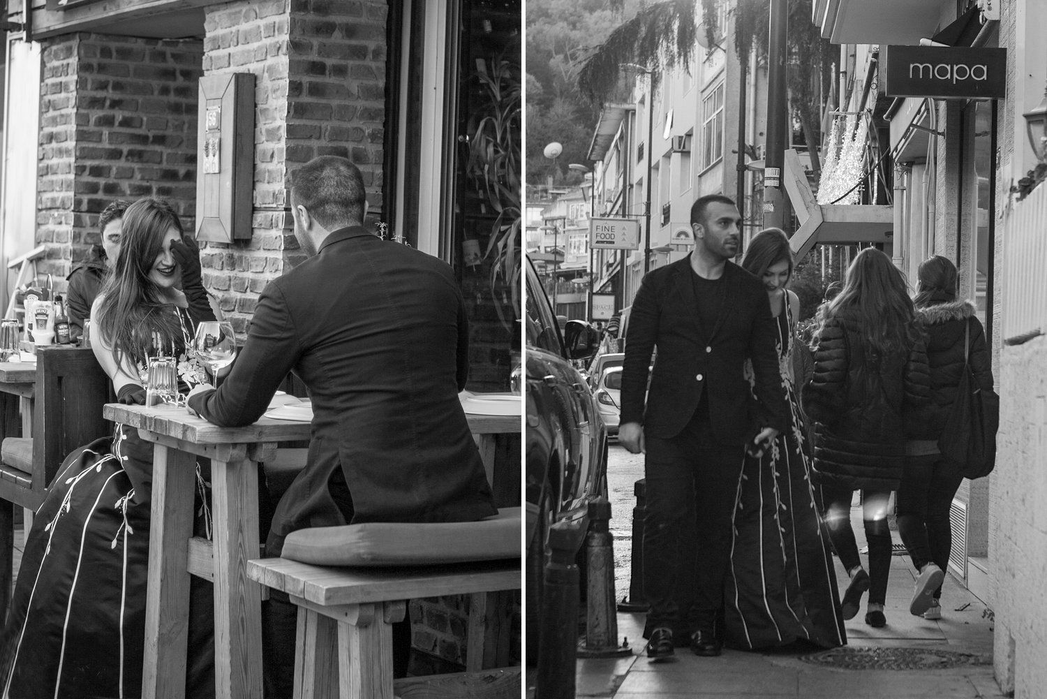 A man and a woman are sitting at a table outside of a restaurant.