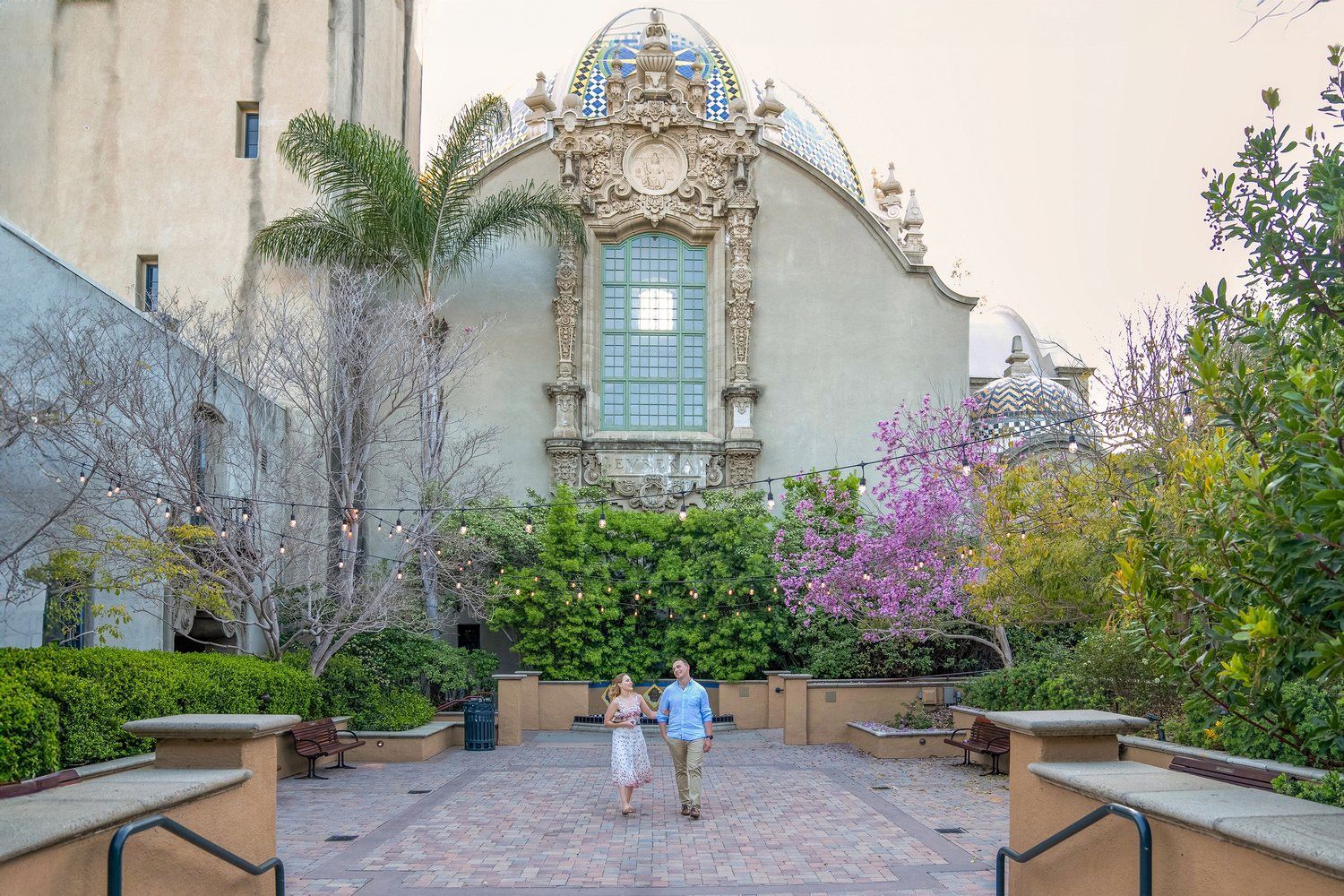 A man and a woman are walking in front of a building.