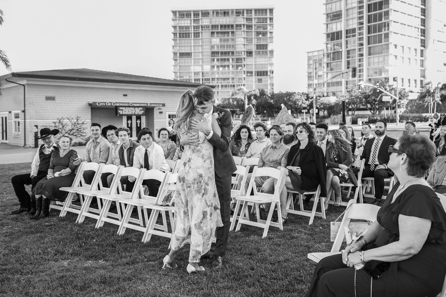 A black and white photo of a bride and groom walking down the aisle at a wedding.