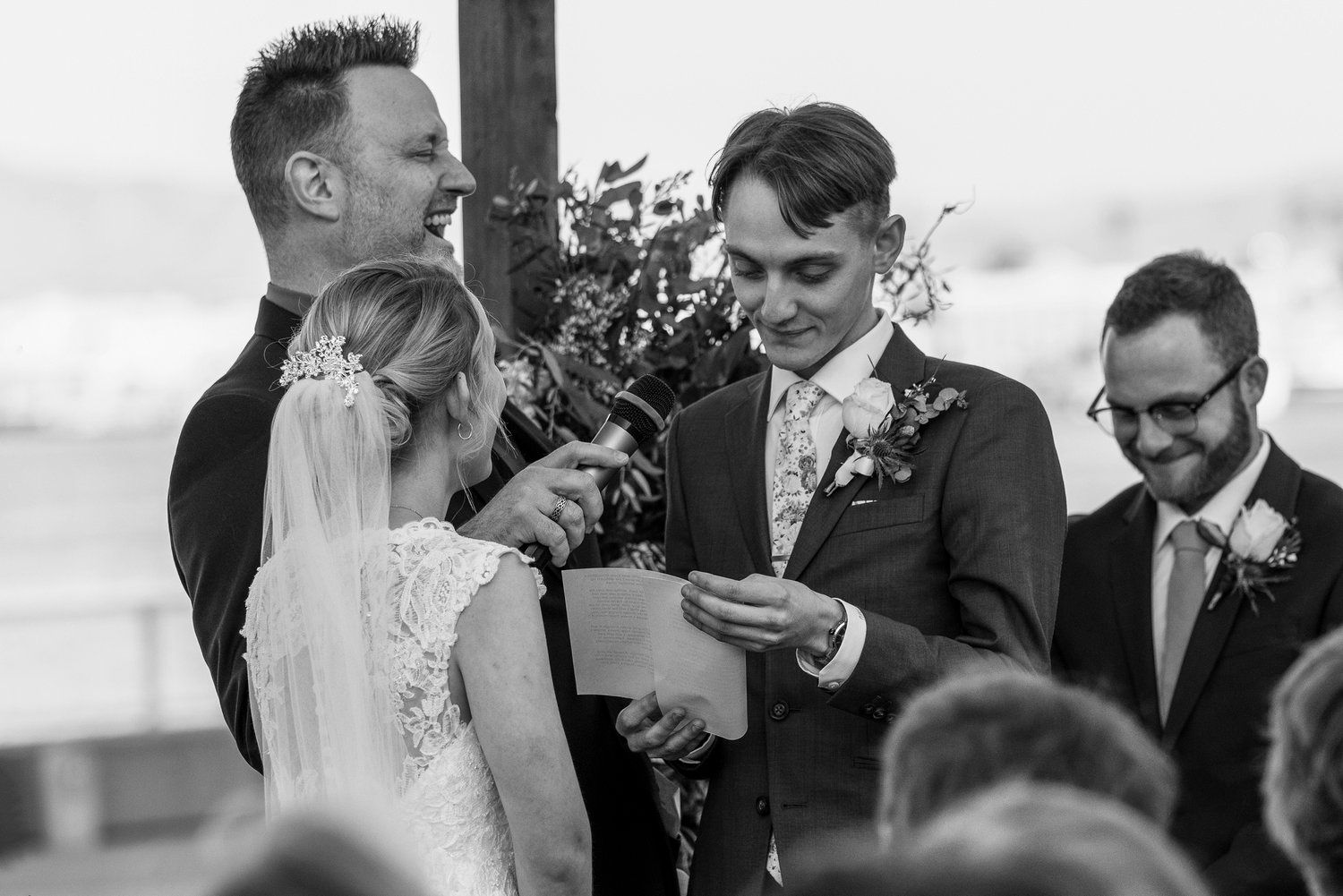 A black and white photo of a bride and groom during their wedding ceremony.