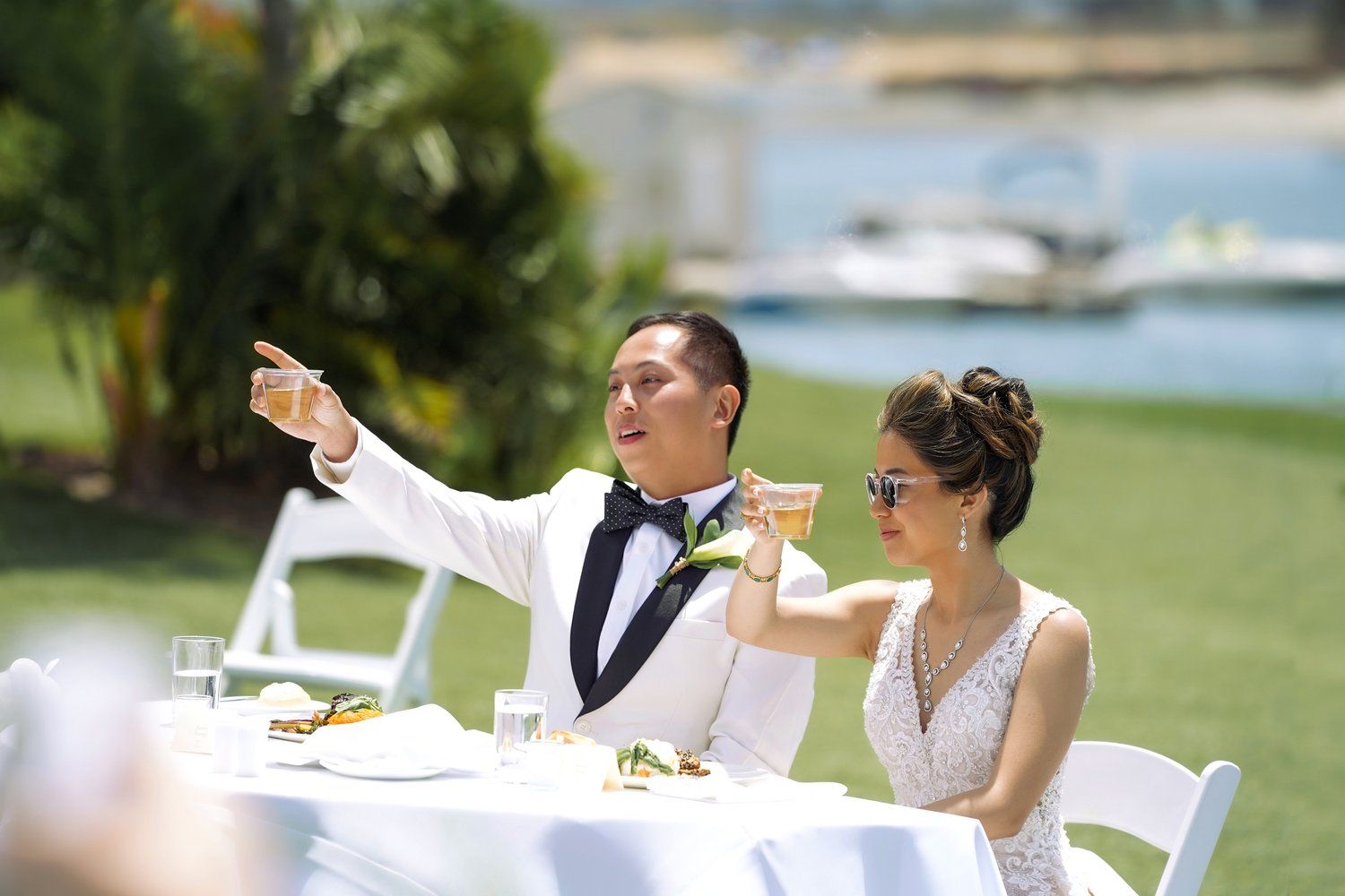A bride and groom are sitting at a table at a wedding reception.