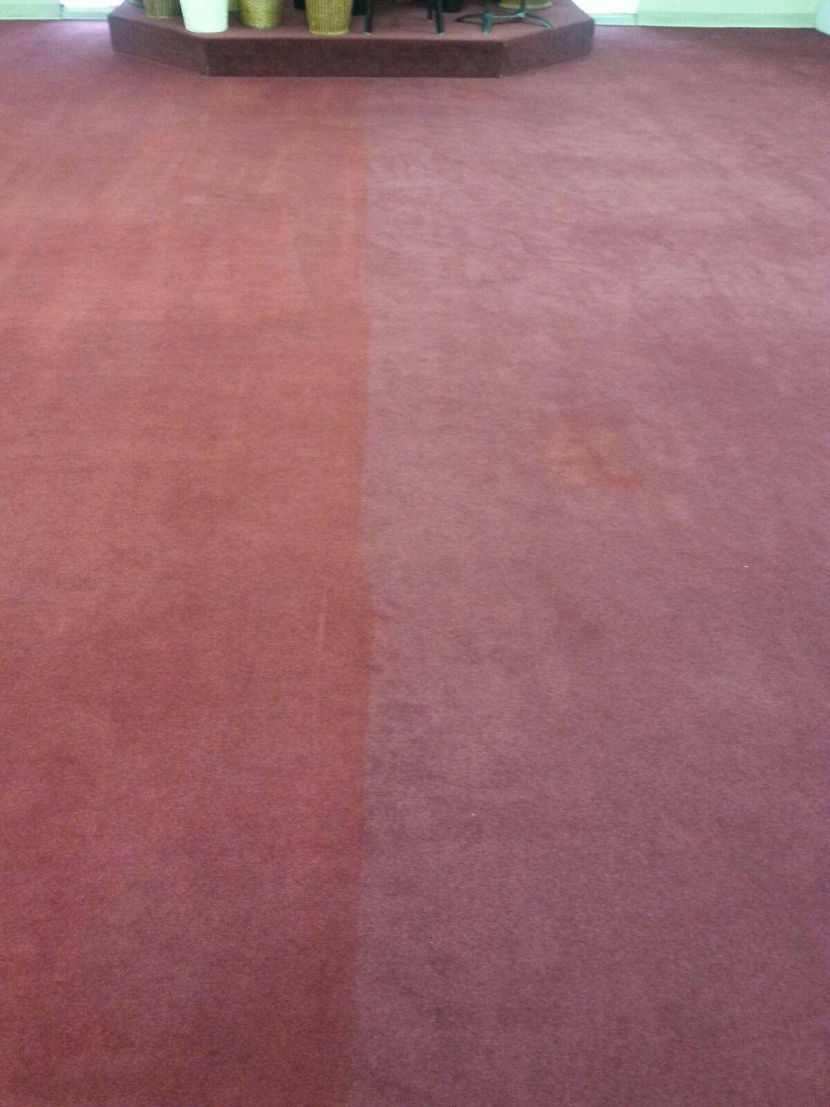 A red carpet is half clean and half dirty in a room.