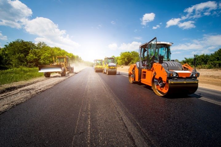 Multiple asphalt rollers paving a road