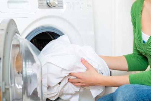 Putting Laundry in Washing Machine — San Antonio, TX — Jesse & Sons Appliance Repair Solutions