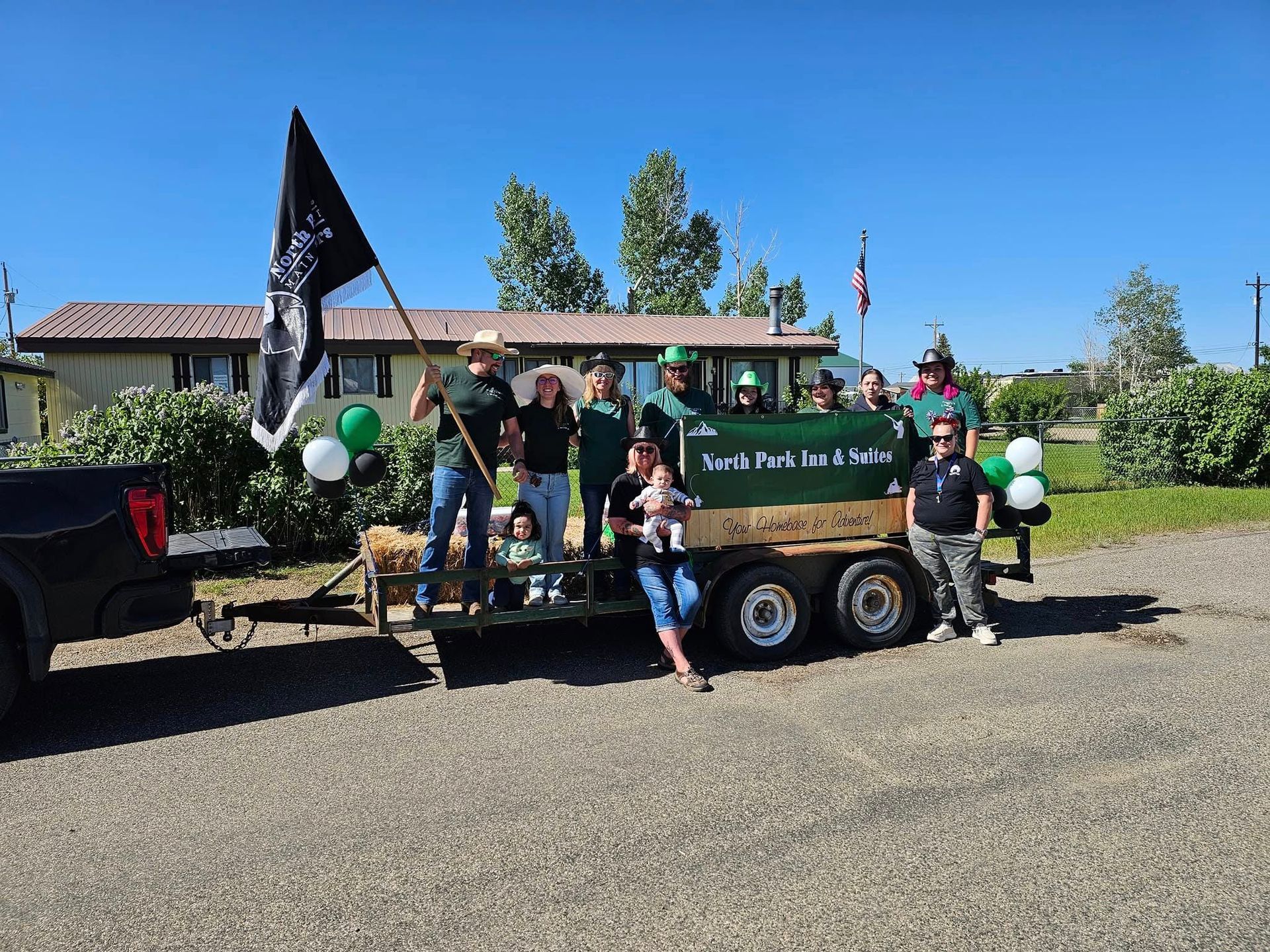 A group of people are posing for a picture in front of a truck and trailer.