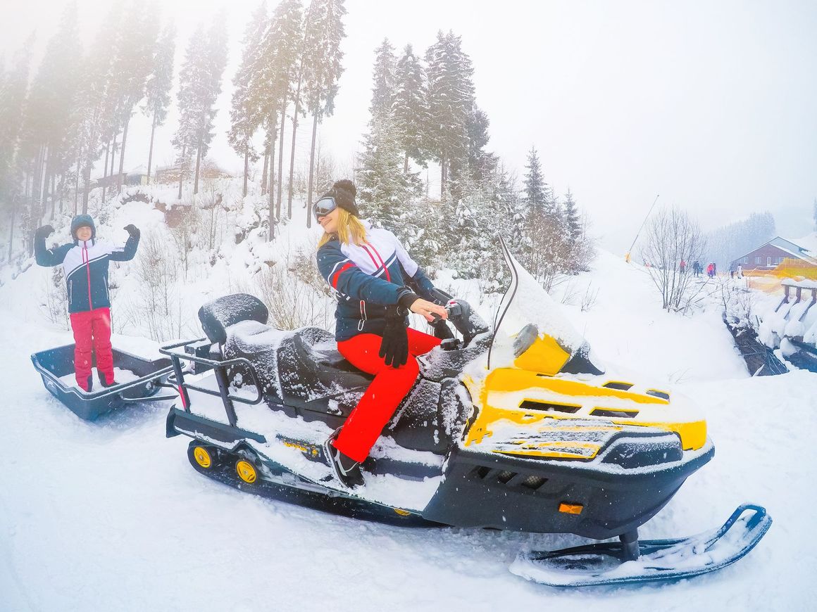 A woman is riding a snowmobile in the snow.