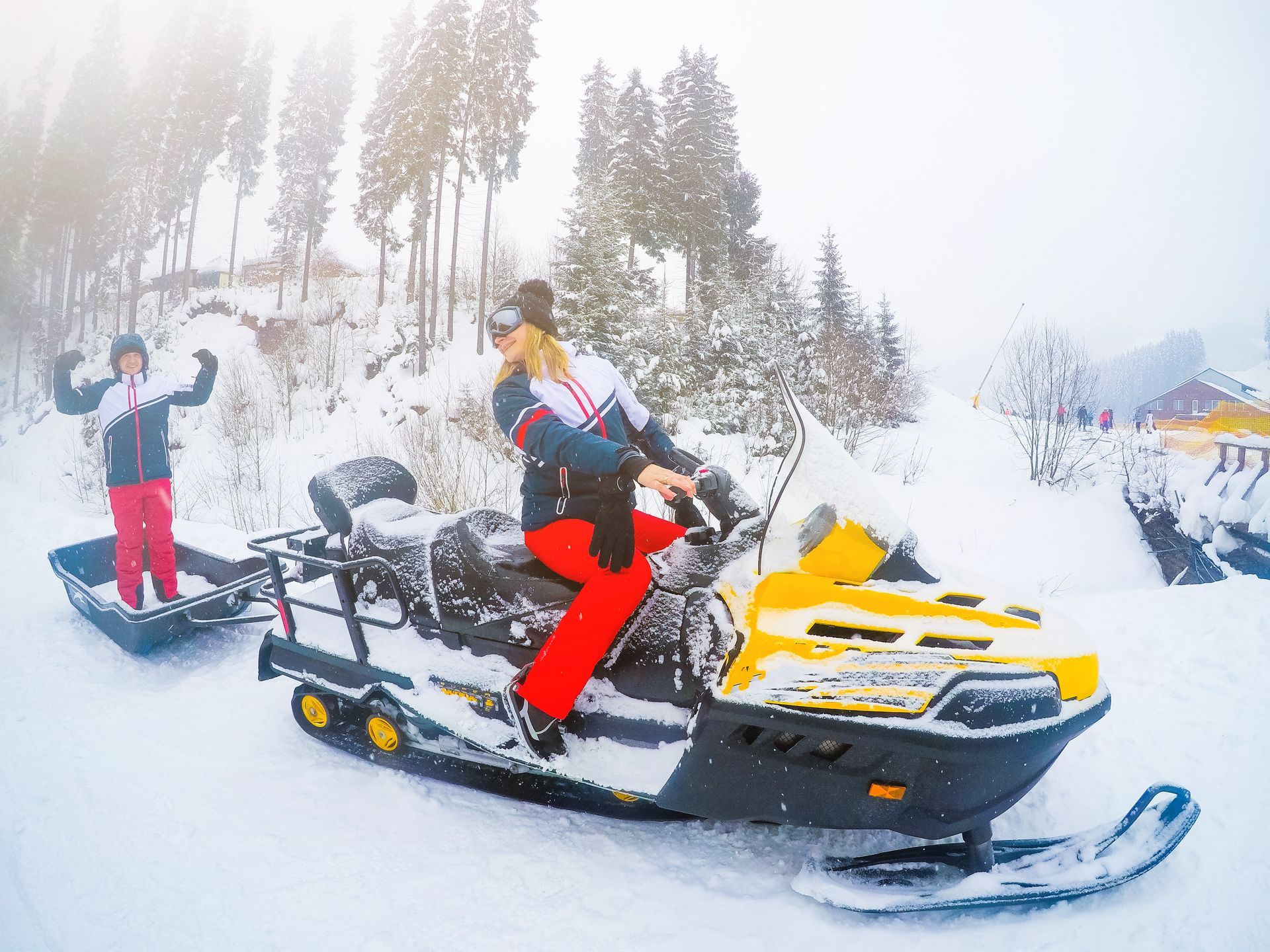 A woman is riding a snowmobile in the snow.