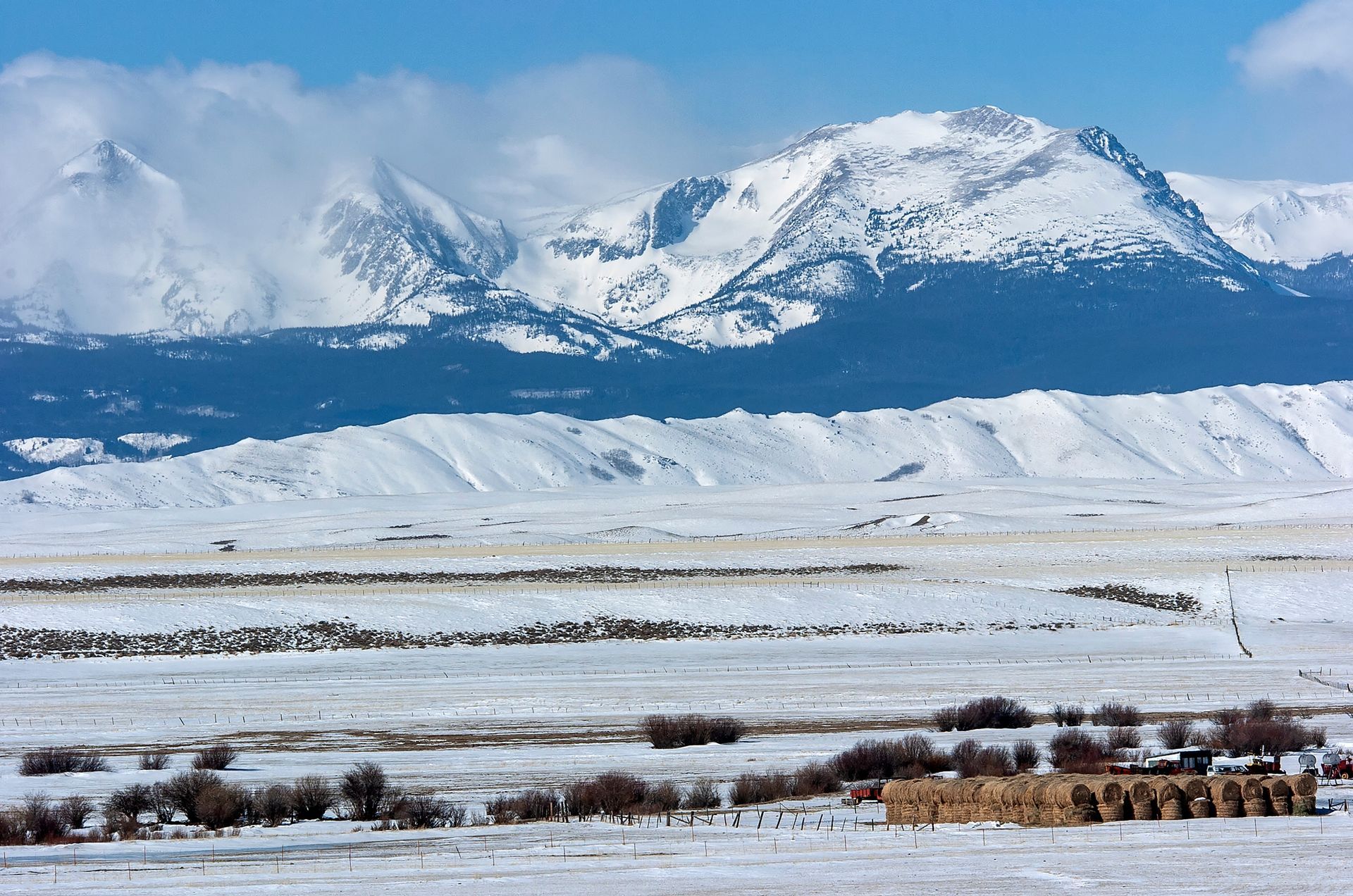 A snowy landscape with mountains in the background