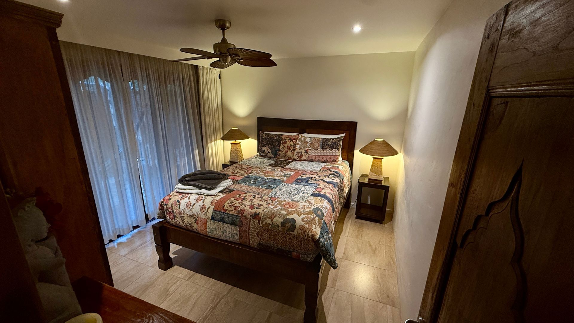 A room with wooden bed and a ceiling fan — Bali at the Bay in Nelson Bay, NSW