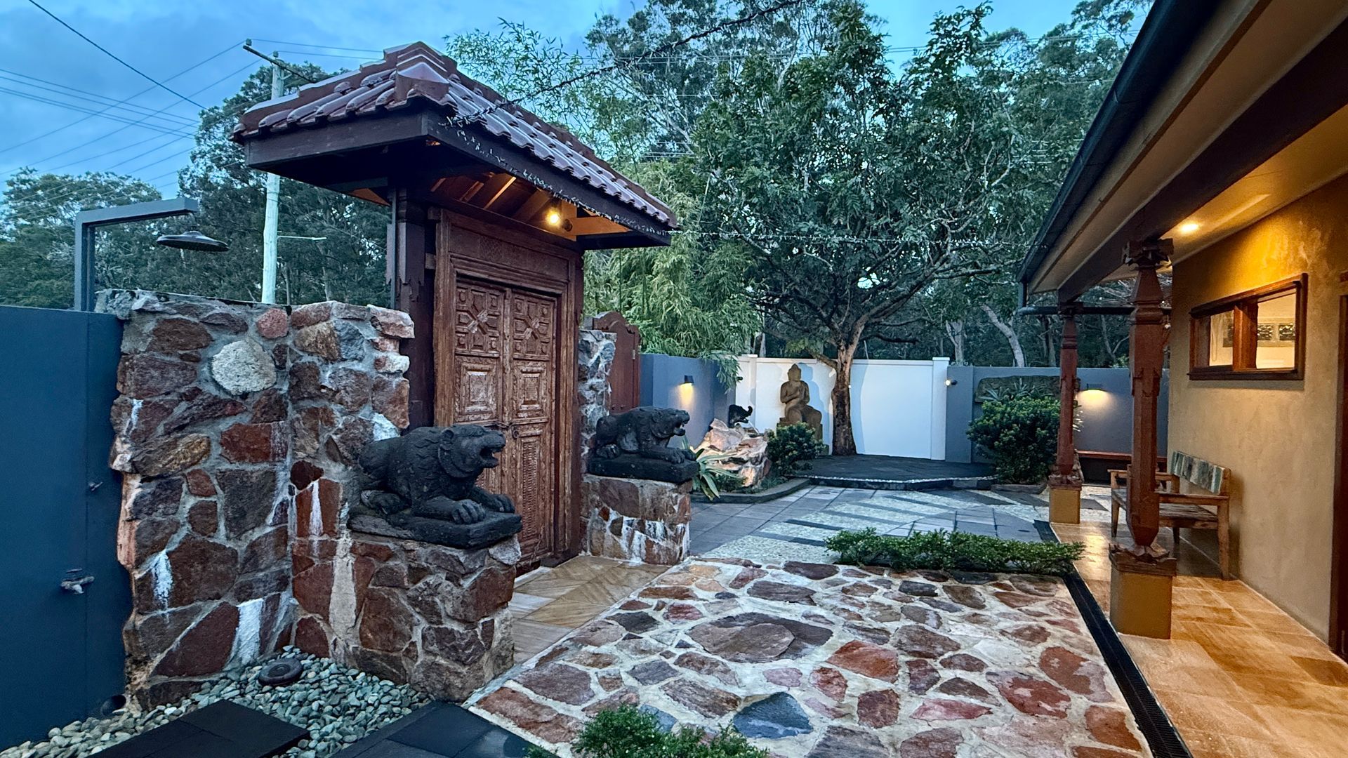 Outdoor stone patio with ornate wooden gate — Bali at the Bay in Nelson Bay, NSW