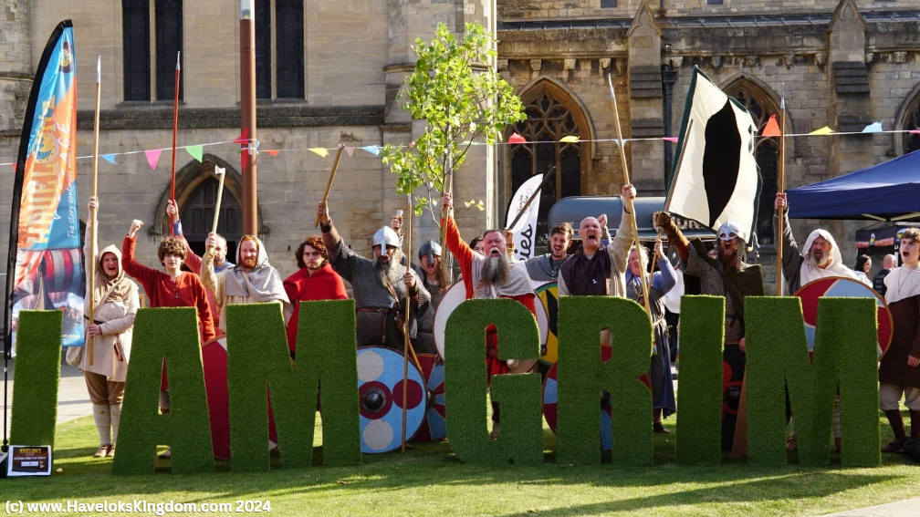 A group of people are standing in front of a large sign that says tam grim.