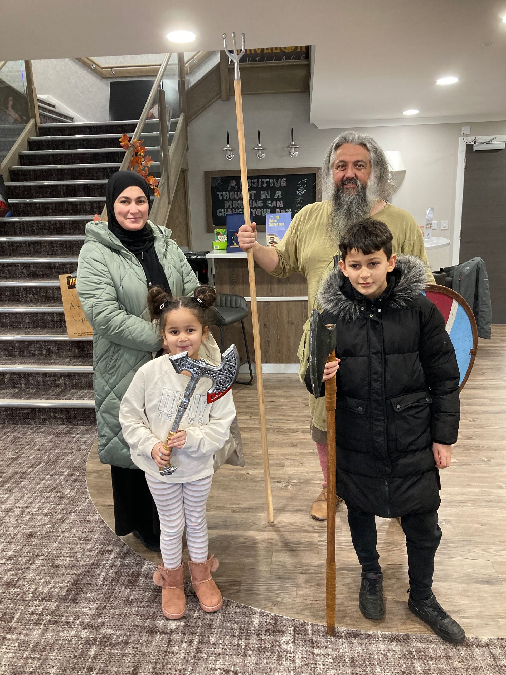 Image of family holding viking axes at an event
