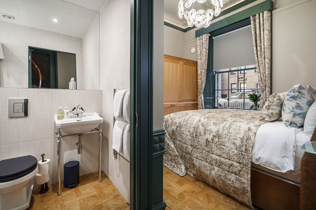 A bedroom with a bed , chair , desk and television.