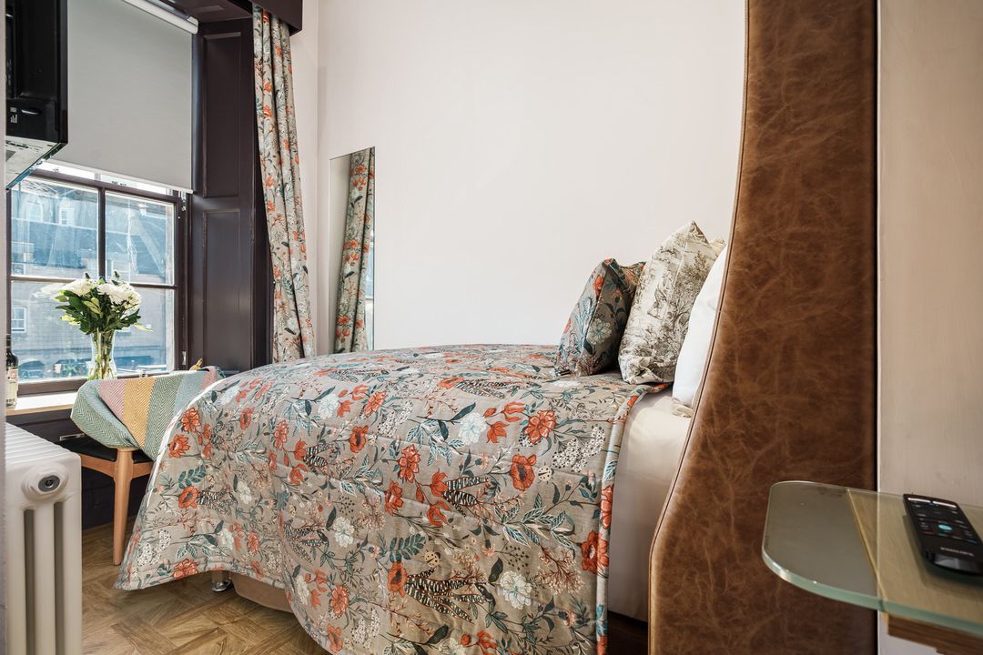 A bedroom with a large bed and a stove in it.