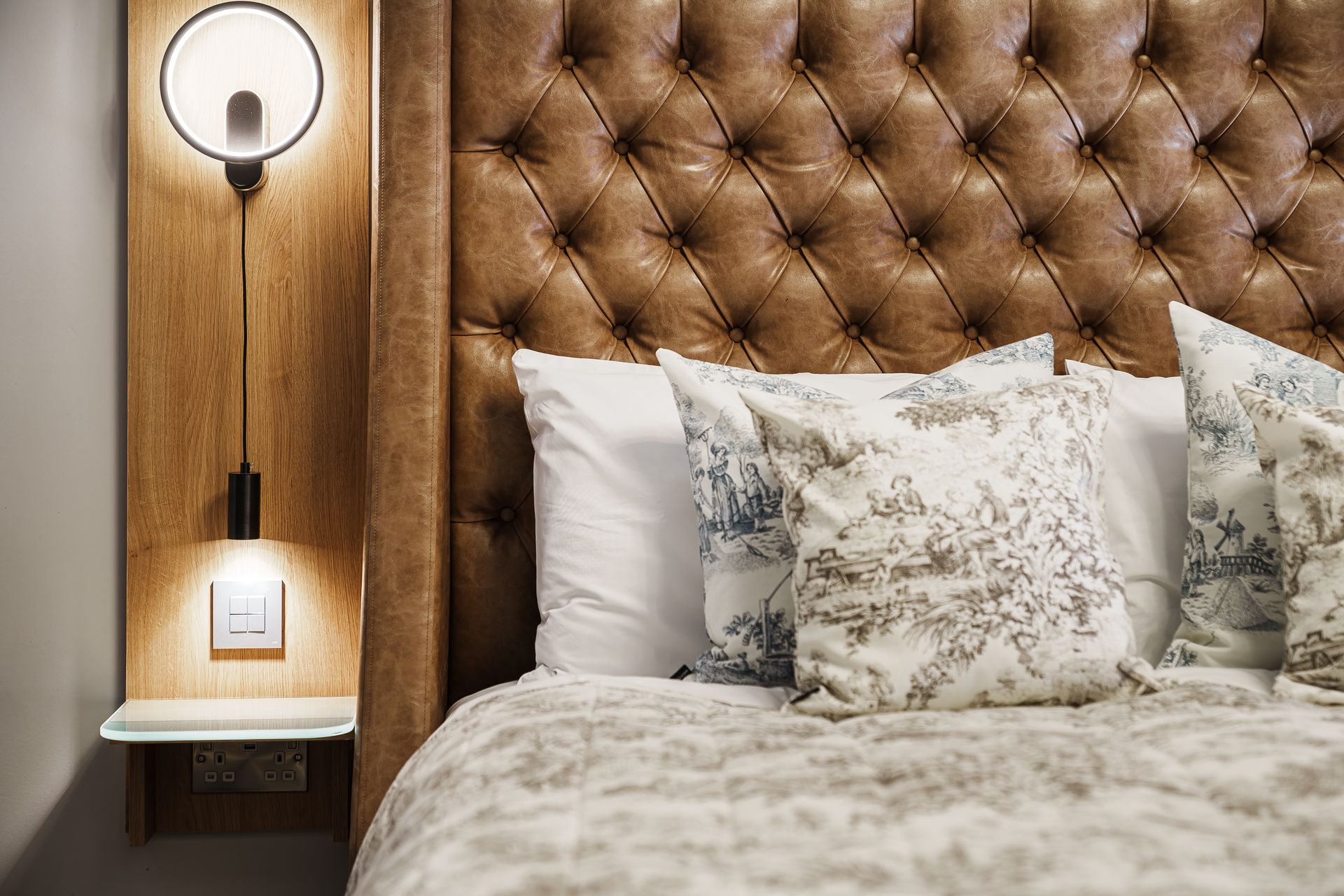 Living room with green accent wall, gray sectional sofa, and round table.