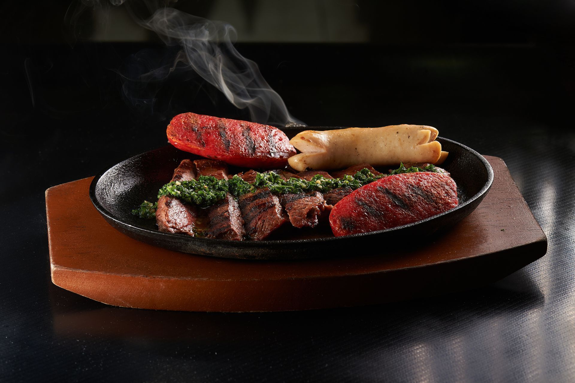 Un plato de comida del que sale humo sobre una tabla de cortar de madera.