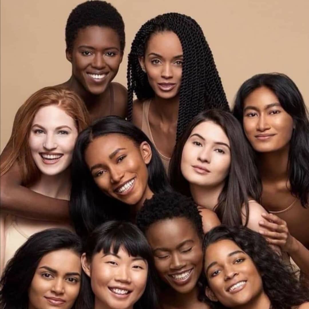A group of women are posing for a picture and smiling