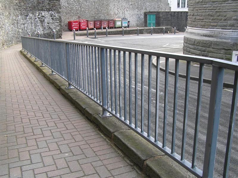 Steel railings on footpath next to road