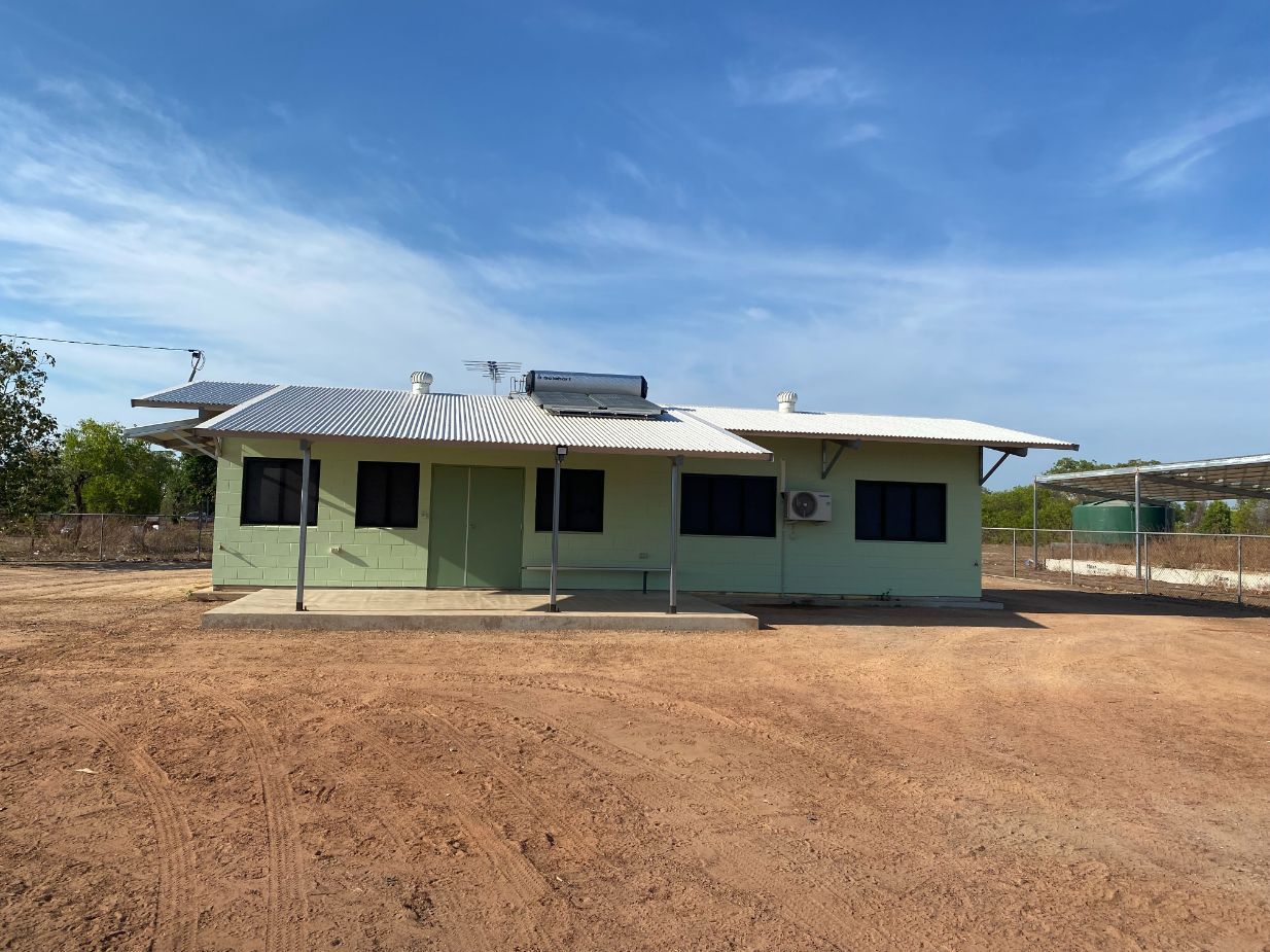 A green house is sitting in the middle of a dirt field — Local Builders in Yarrawonga, NT